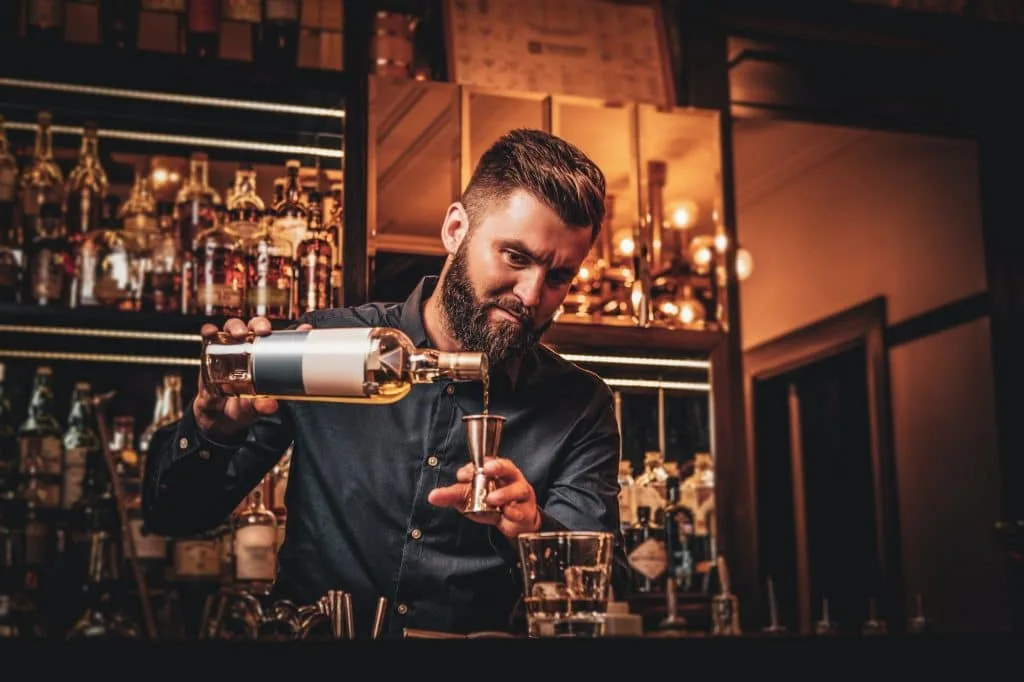 Bartender blandar en drink i baren